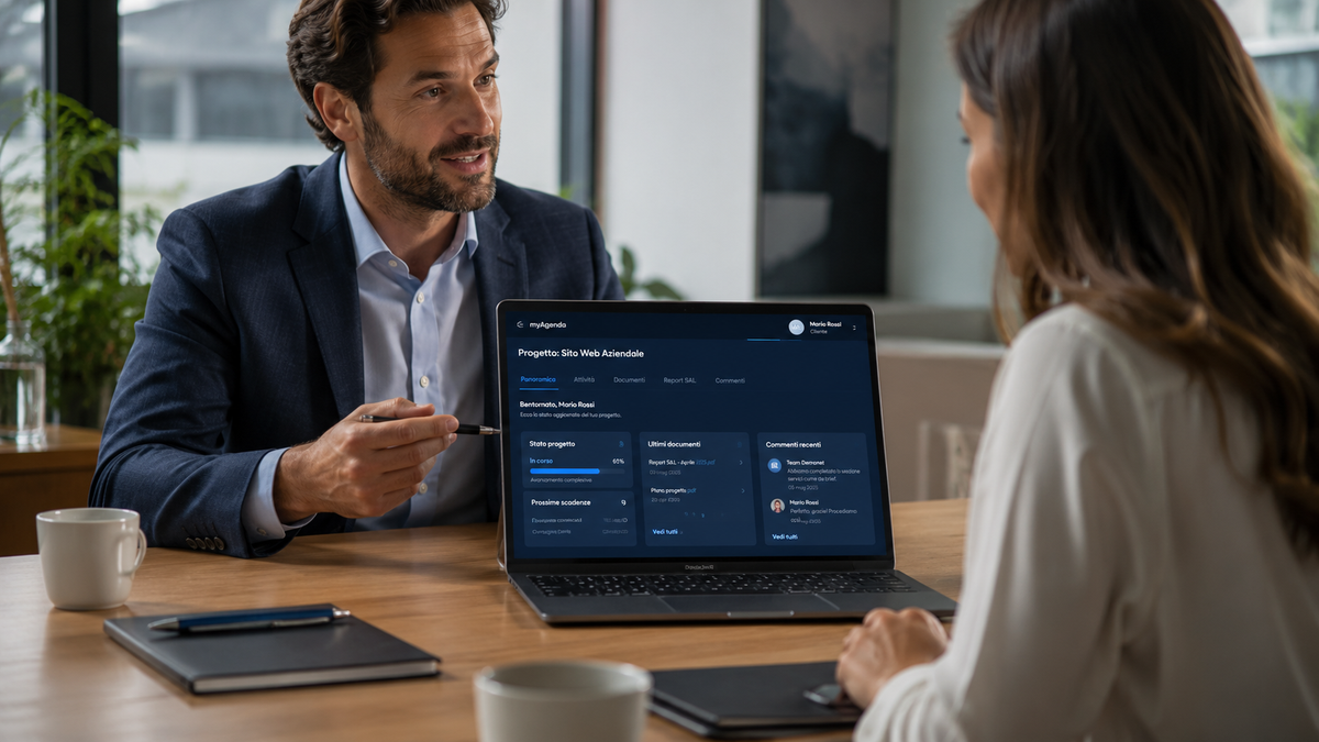 Un consulente mostra a una cliente, sullo schermo di un portatile, il portale cliente di myAgenda: stato di avanzamento del progetto, prossime scadenze, ultimi documenti e commenti condivisi con il team.