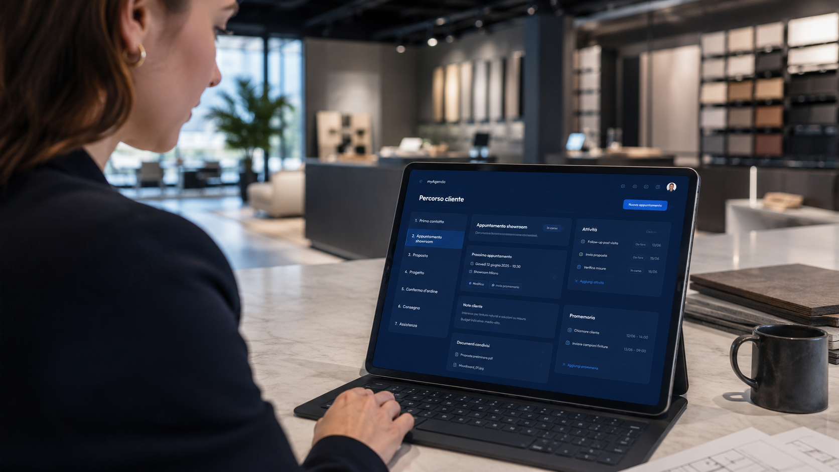 Showroom arredamento con tablet myAgenda che mostra il percorso cliente dal contatto alla consegna